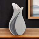Gray and off-white tulip ceramic vase with sequins on table