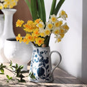 Close-up of hand-painted pomegranate design on blue and white ceramic vase showcasing fine craftsmanship.