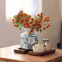 Traditional blue and white porcelain vase with pomegranate motif displayed on mantel or table for stylish home accent.