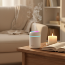 Compact portable mini USB humidifier with soft mist rising on a wooden nightstand in a cozy reading nook